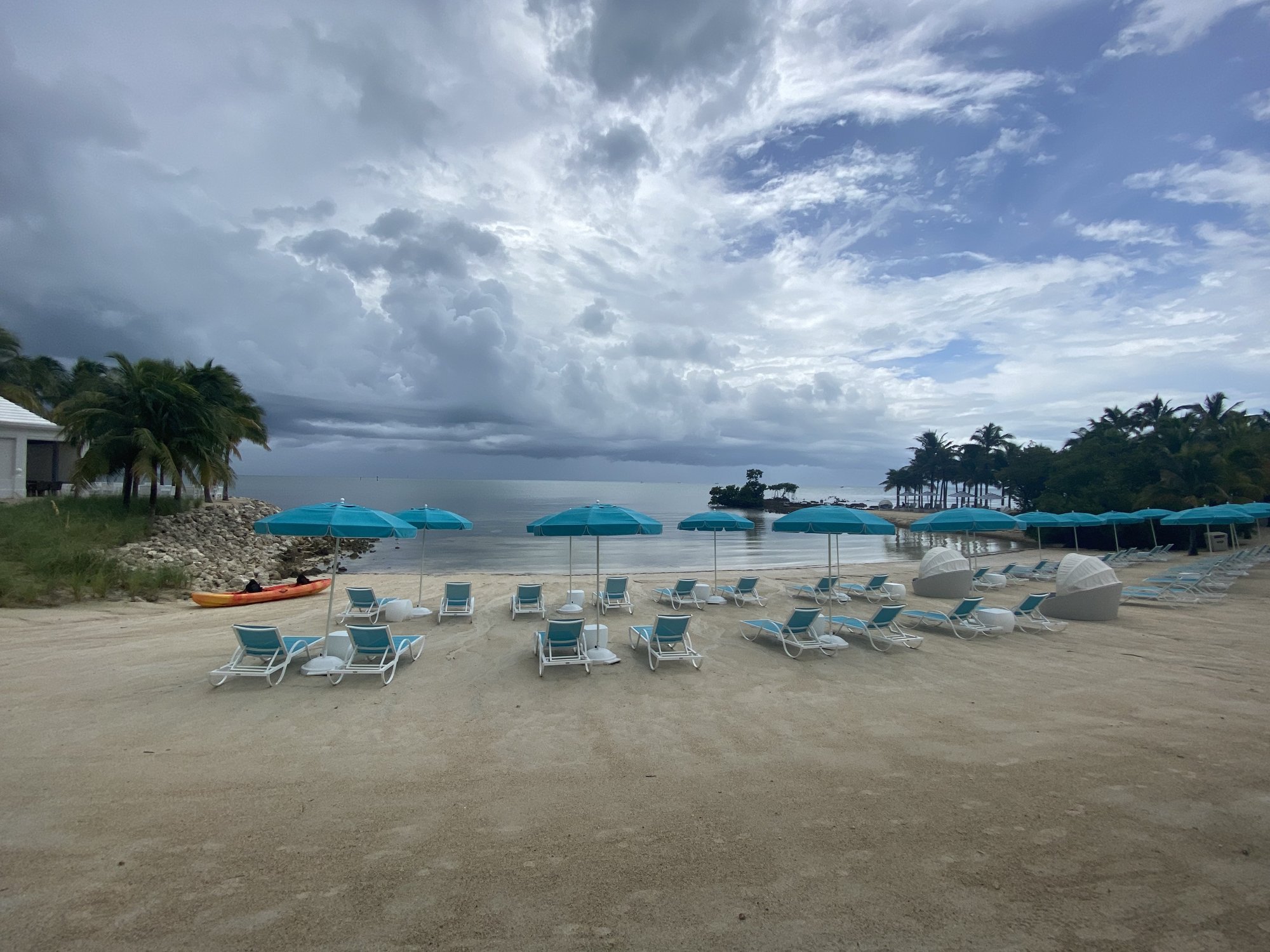 Teal beach umbrellas before a storm